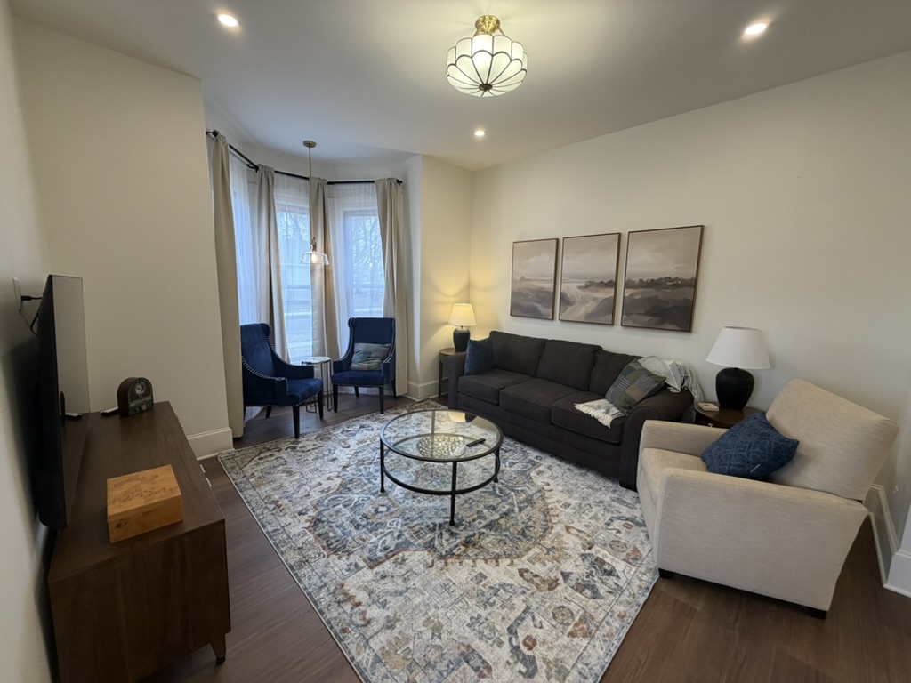 Comfortable living room at Darrell’s House with bay-window seating and layered navy furnishings